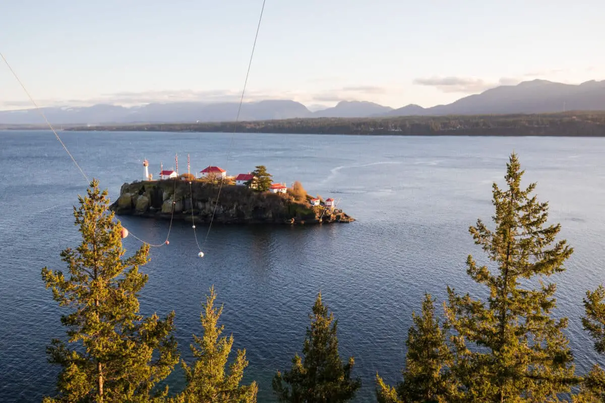 The red-and-white Chrome Island Lighthouse buildings, from the viewpoint in Boyle Point Provincial Park on Denman Island, BC