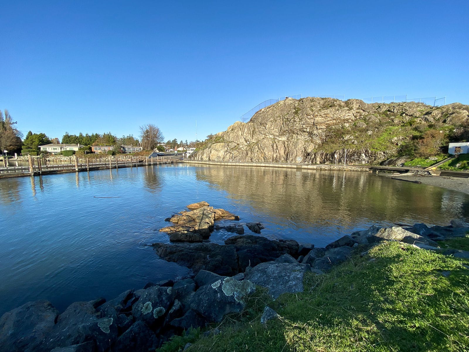 The calm ocean water, docks and climbing wall at Fleming Beach