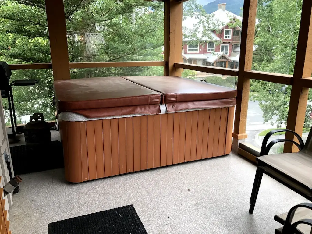 The hot tub (with a cover on) on the covered deck of the Glacier's Reach Townhouse in Whistler, BC