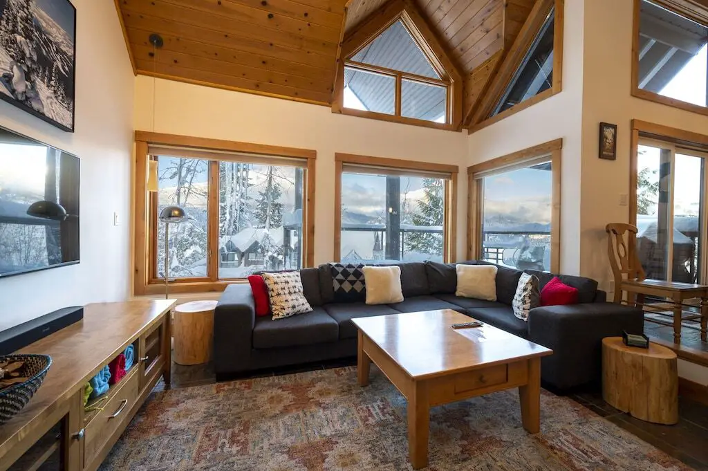 The living room at the Luxury Slopeside Chalet, with views of Whistler in winter outside the winters