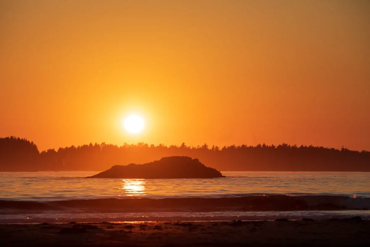 The orange sunset over Wickaninnish Island from North Chesterman Beach in Tofino