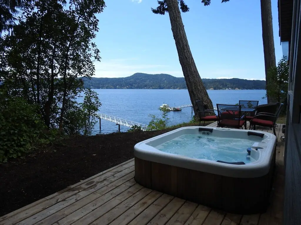 The hot tub overlooking the ocean at the Sooke Oceanfront Cottage, one of the best VRBO vacation rentals in Sooke