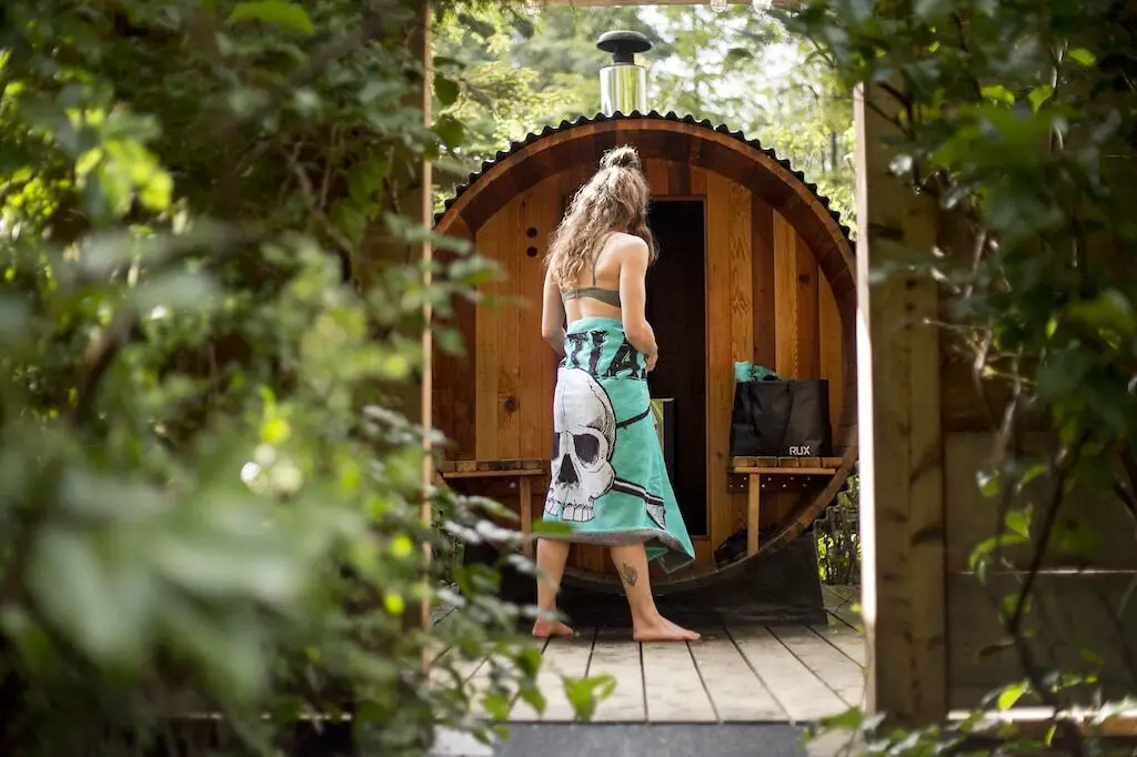 A woman walking in front of the sauna at the Waterfront Luxury Retreat in Tofino