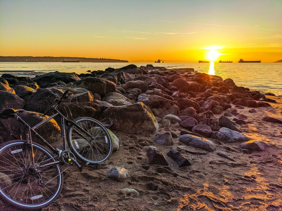 A bike leaning on the rocks at a beach in Vancouver