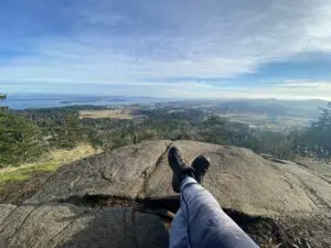 Hiker sitting at Pickles' Bluff in John Dean Provincial Park in Victoria, BC