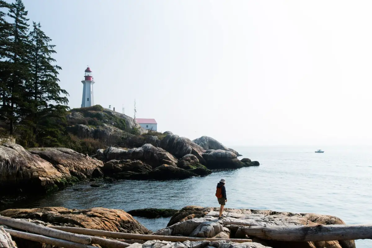 A person standing in front of the lighthouse at Lighthouse Park in West Vancouver