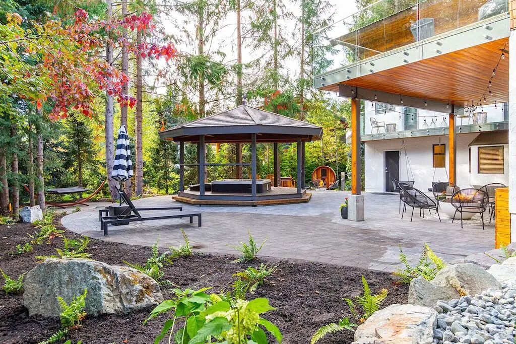 The hot tub, barrel sauna, and outdoor fireplace at the Mountain Modern Chalet in Whistler, BC