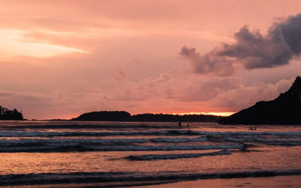 Surfing under a pink sunset in Tofino